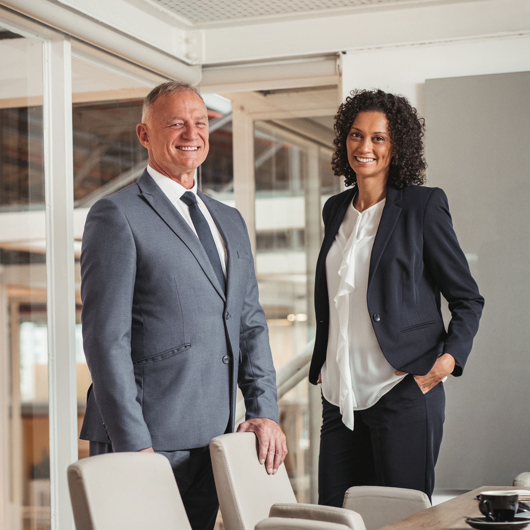 2 professionals in an office smiling